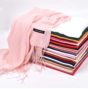 Detail view of pink cashmere scarf with fringes and various color options behind