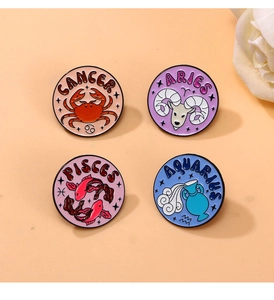 Detailed set of four colorful enamel zodiac pins featuring Cancer, Aries, Pisces, and Aquarius