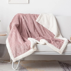 Detail of pink striped flannel and white sherpa fleece lining on a thick winter blanket