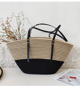 Close-up of woven tote bag with beige cotton rope texture and black leather straps