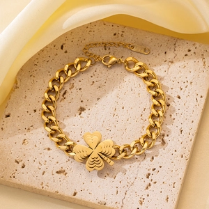 Detalle de un trébol de oro 18K con textura de corazones en una cadena cubana gruesa