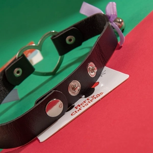 Black leather choker with heart ring, purple bow and bell on Christmas gift card