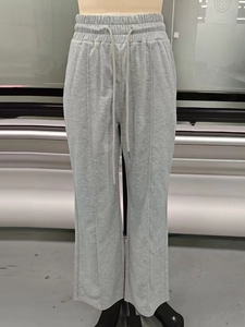 Detail of grey high-waisted wide-leg sweatpants featuring drawstring and front seam line