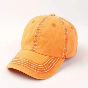 Detail of vintage washed cotton orange baseball cap with contrast stitching and eyelets