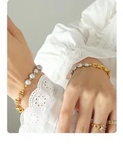 Detail of gray freshwater pearl bracelet with gold spiral chain and a matching chain ring