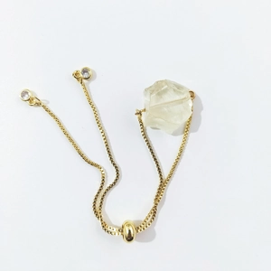 Detail of adjustable gold box chain bracelet with large irregular natural quartz stone