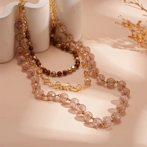 Vintage multi-layer necklace with golden chains, brown beads, and champagne glass beads