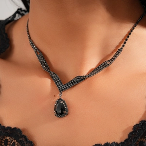 Detailed view of luxury black teardrop crystal pendant necklace on model neckline