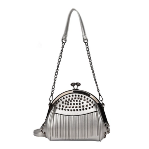 Silberne muschelförmige Handtasche mit Nietenbesatz und metallischen Fransenketten