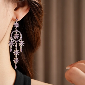 Close-up of purple zircon flower tassel earrings worn to show elegant hanging detail