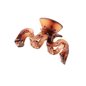 Detailed top view of a large amber wavy claw clip with translucent resin finish
