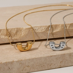 Polished U-shaped pendant necklaces with heart cutouts on gold and silver snake chains