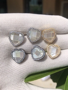 Gros plan de boucles d'oreilles en forme de cœur avec nacre et zircons incrustés