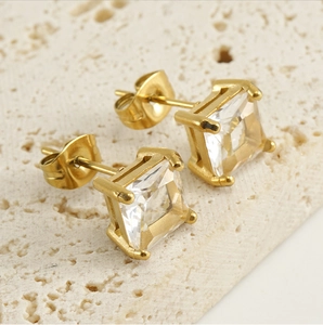 Vue macro de boucles d'oreilles carrées en zircone avec placage en or 18 carats et serti griffes