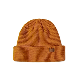 Detailed texture of thick ribbed knit beanie with brown faux leather patch in ginger yellow
