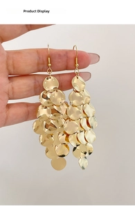 Dettaglio di orecchini a cerchio dorati multistrato con paillettes metalliche lucide