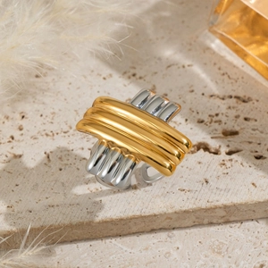 Macro shot of two-tone gold and silver crossover ring on elegant stone background