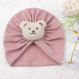 Soft pink knitted baby turban hat with a cute white plush bear patch for infants