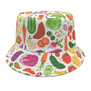 Close-up of bucket hat with vibrant vegetable prints like carrots and tomatoes on white cotton