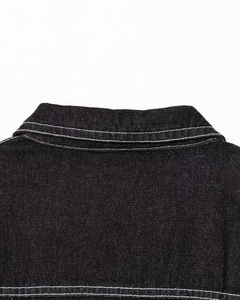 Detailed view of black denim collar with contrast white topstitching on the edges