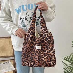 Leopard print canvas tote bag detail featuring the signature brand label and texture
