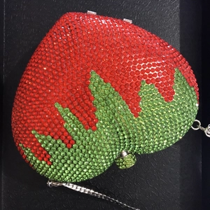 Close-up of sparkling red and green rhinestones on the strawberry-shaped evening clutch bag