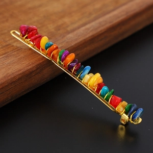 Detail of colorful crystal gravel stones hand-wound on a golden metal hair clip base