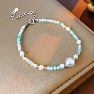 Détail d'un collier de perles artificielles et perles bleues sur un coffret à bijoux
