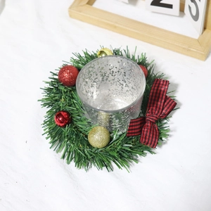 Close-up of glass candle holder with pine wreath and red black buffalo plaid bow