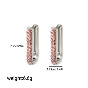 Macro view of silver U-shaped earrings with pink rhinestones showing 2.55cm height
