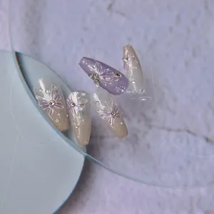 Detail of purple gradient nail stickers featuring 3D butterfly designs and pearl accents
