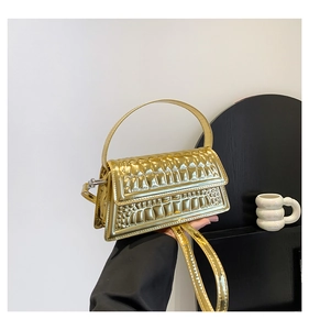 Detailed macro view of golden faux leather handbag with 3D embossed crocodile texture