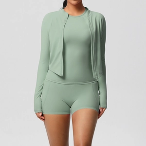 Détail de l'ensemble yoga vert sauge avec short taille haute et veste zippée cousue