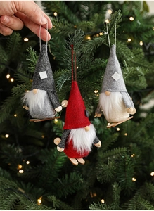 Detail of felt gnome ornaments with wooden skis hanging on a Christmas tree