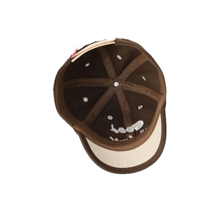 Inside view of brown and beige kids baseball cap showing embroidery and 6-panel stitching