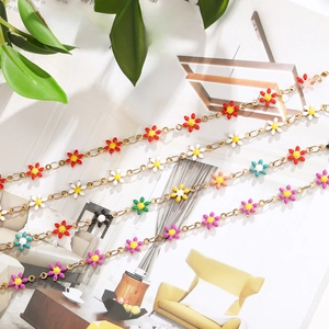 Detailed view of multiple colorful enamel flower charms on golden stainless steel chains