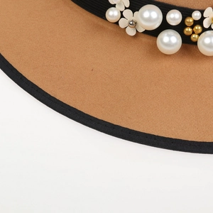 Close-up of brown wool felt fedora with white pearls, floral accents and black stitched brim
