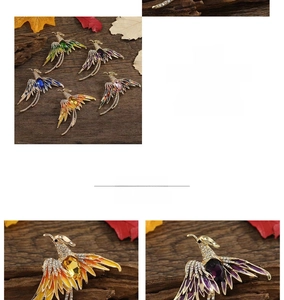 Detailed macro view of colorful phoenix brooches with enamel wings and sparkling rhinestones