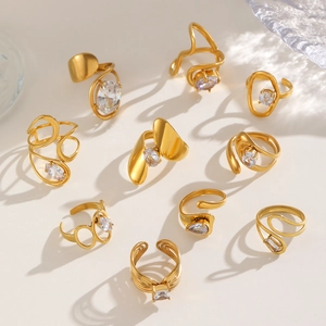 Irregular golden geometric rings with clear zircon stones on a minimalist beige background