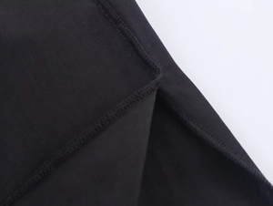 Detailaufnahme von schwarzem Strickstoff mit professioneller Overlock-Nahtverarbeitung