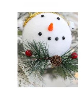 Dettaglio di pupazzo di neve con naso arancione, pigne e bacche rosse natalizie