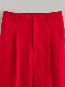 Détail du pantalon de costume rouge avec plis avant, passants et texture tissée
