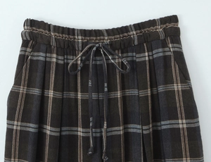 Close-up of elastic waistband with drawstring and side pocket on plaid trousers
