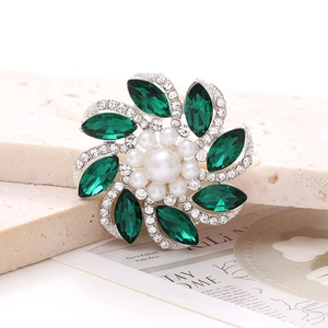 Detalle de broche de flor de lujo con cristales verdes y perlas elegantes