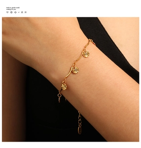 Macro detail of wave chain bracelet with radial textured charms and K18 hallmark tag