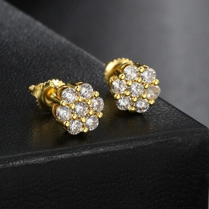 Macro detail of gold flower stud earrings with sparkling crystals and screw back