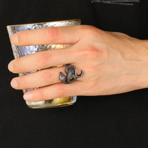 Dettaglio macro dell'anello a serpente retrò con occhi di rubino e scaglie metalliche