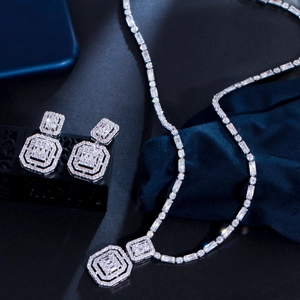 Close-up of vintage square zircon jewelry set with necklace and earrings on dark velvet