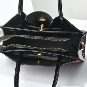 Detailed top view showing three interior compartments with a gold zipper and croc-pattern leather