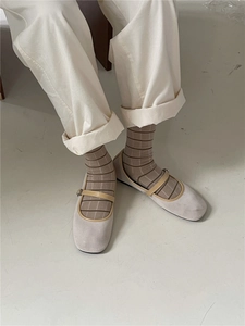 Detail of beige suede Mary Jane flats with brown buckle and striped Morandi mid-calf socks